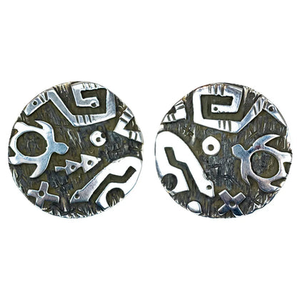 Pair of silver and black patterned earrings on a white background