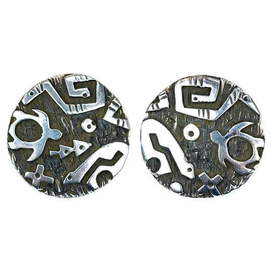 Pair of silver and black patterned earrings on a white background