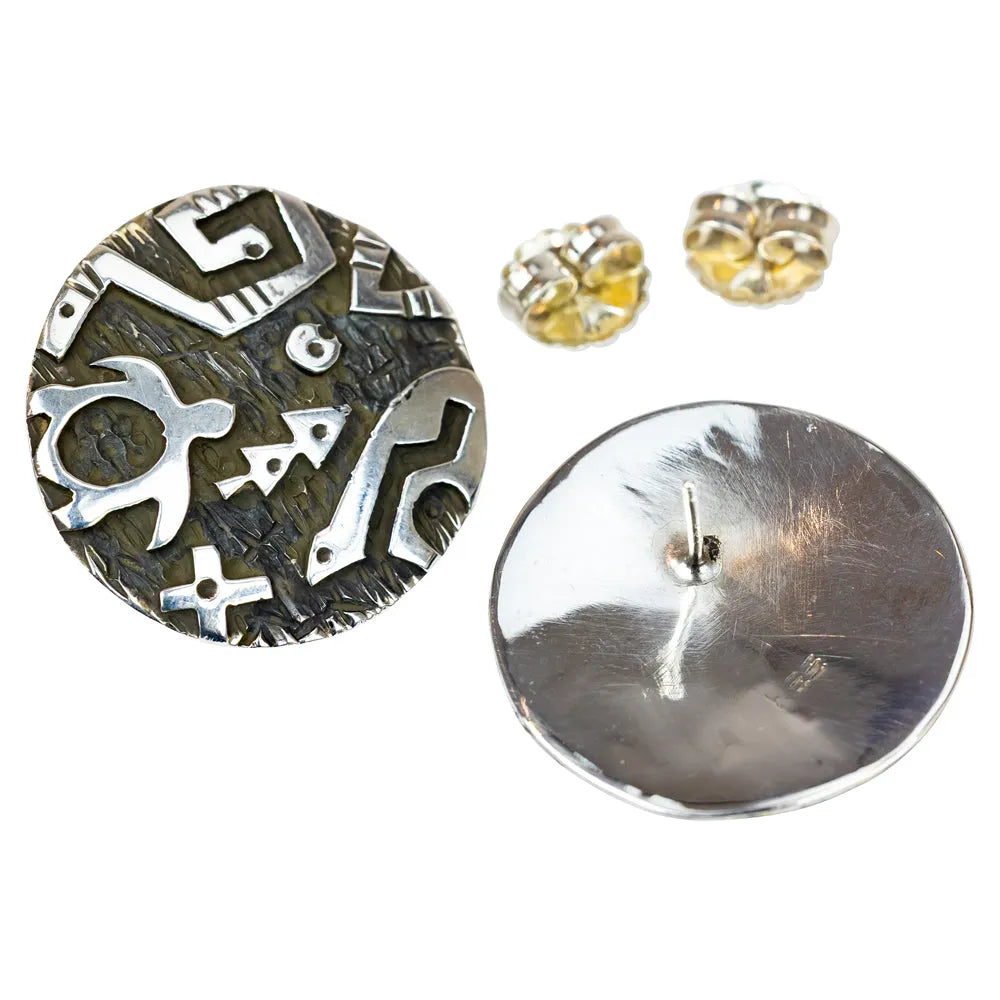 Pair of silver and black patterned earrings on a white background