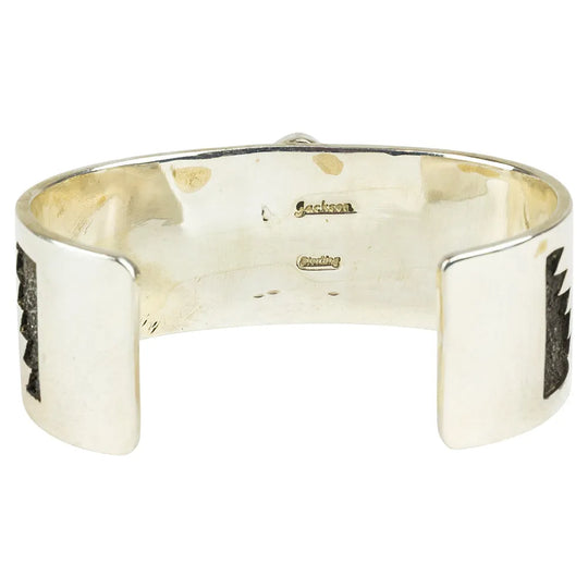 Silver cuff bracelet interior view with hallmark on a white background