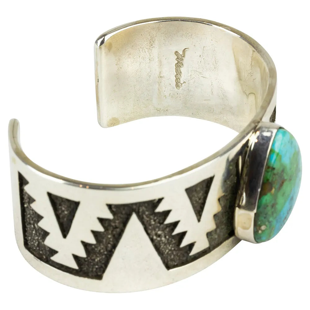 Silver cuff bracelet with geometric design and turquoise stone inside view with hallmark on a white background