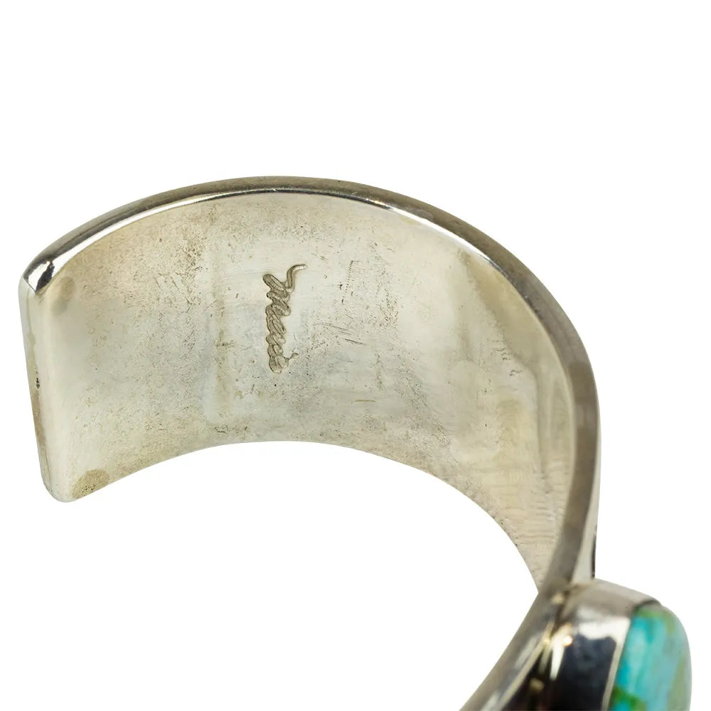 Close-up of hallmark in silver Navajo cuff bracelet on a white background