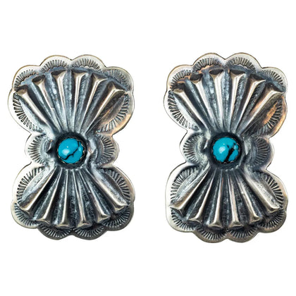 Pair of silver concho-style earrings with turquoise stones on a white background