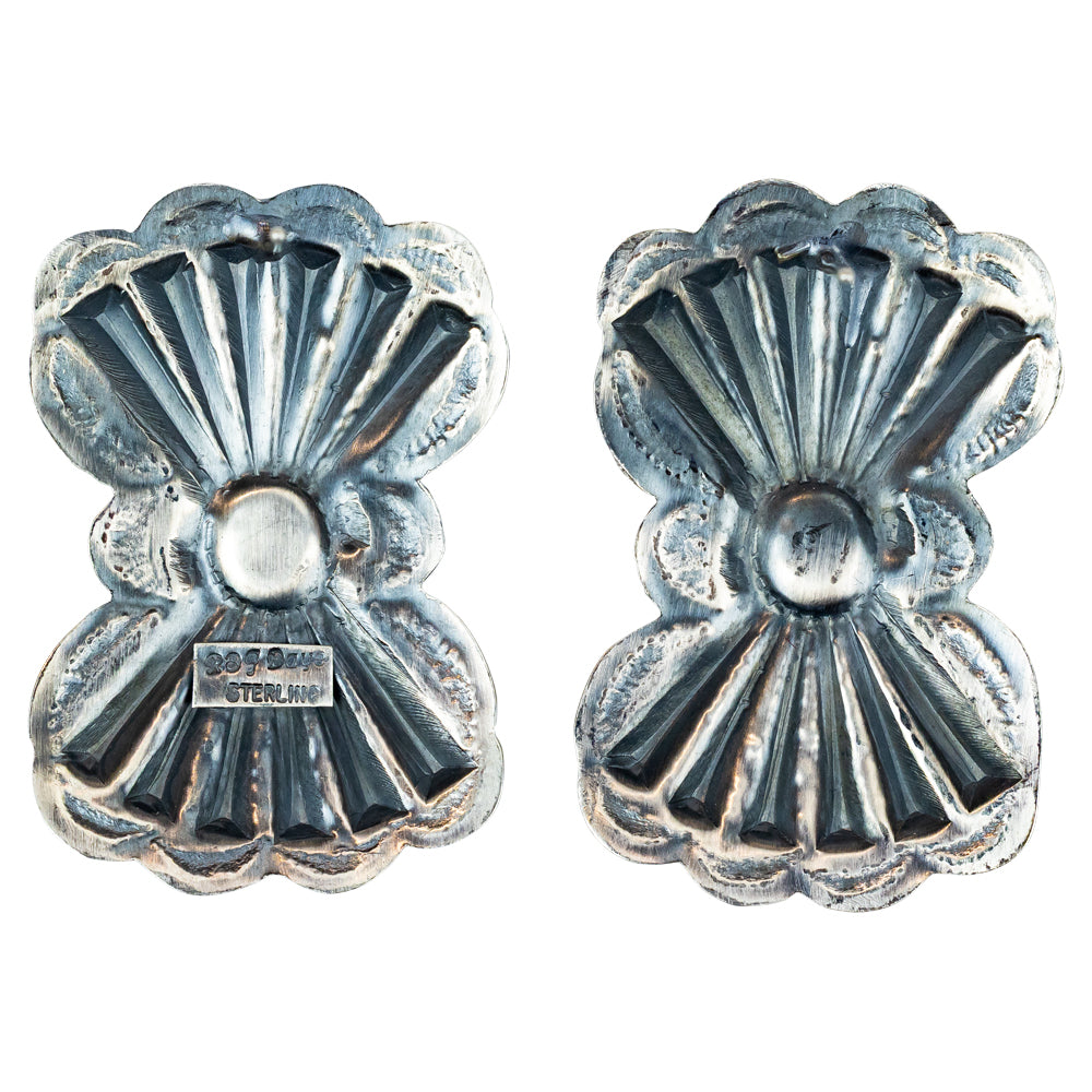 Pair of silver concho-style earrings with turquoise stones on a white background