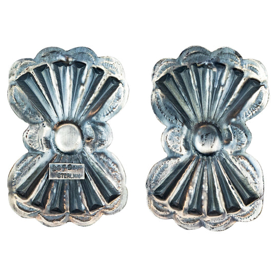 Pair of silver concho-style earrings with turquoise stones on a white background