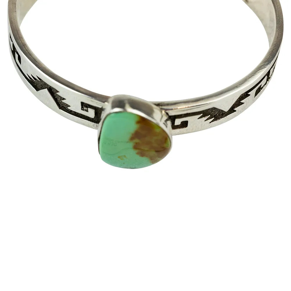 Silver ring with a green turquoise stone on a white background