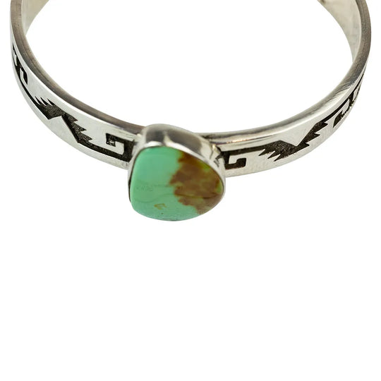 Silver ring with a green turquoise stone on a white background