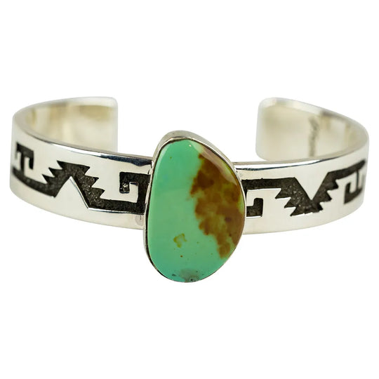 Navajo silver bracelet with a green turquoise on a white background