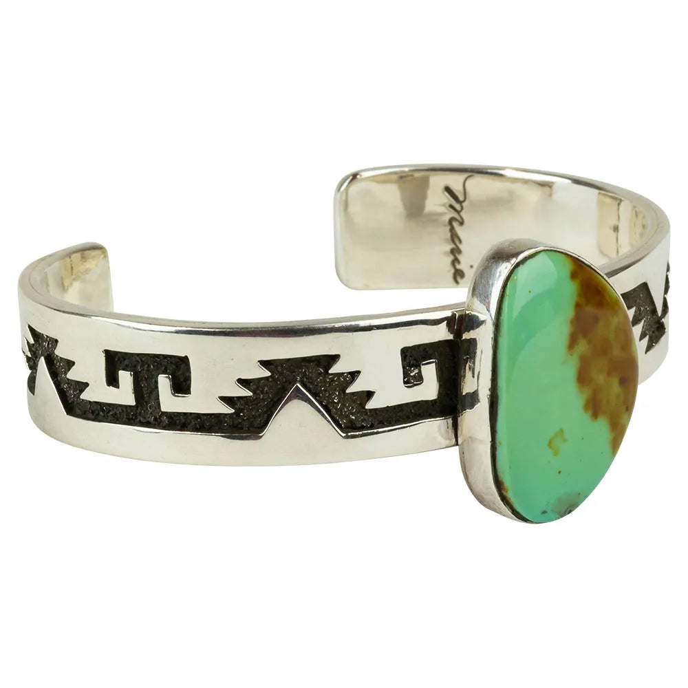 Silver Navajo cuff bracelet with a turquoise stone on a white background