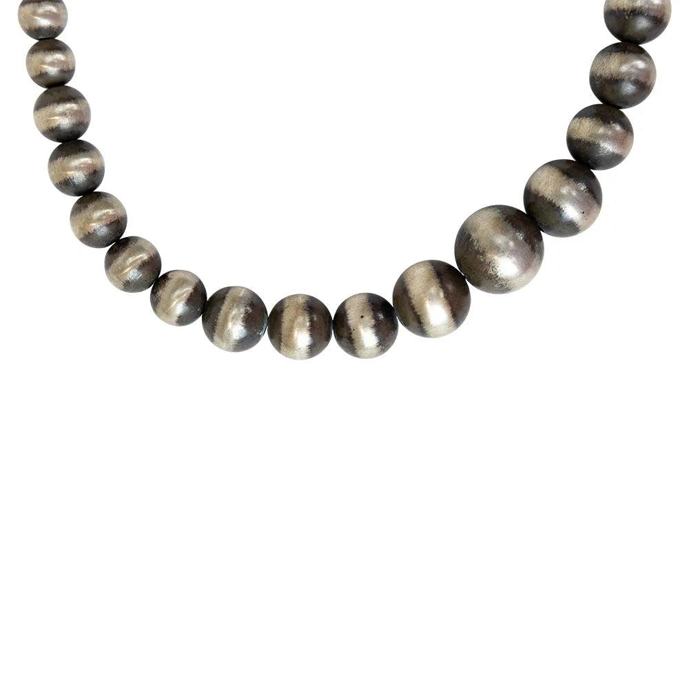 Detail of silver Navajo pearl bead necklace on white background
