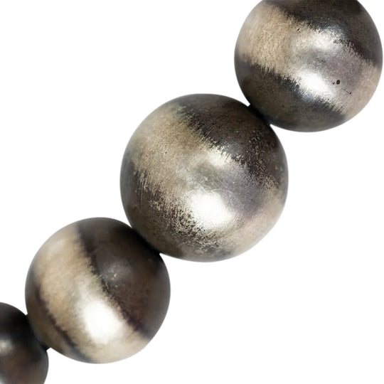 Close-up of silver Navajo pearl beads on a white background