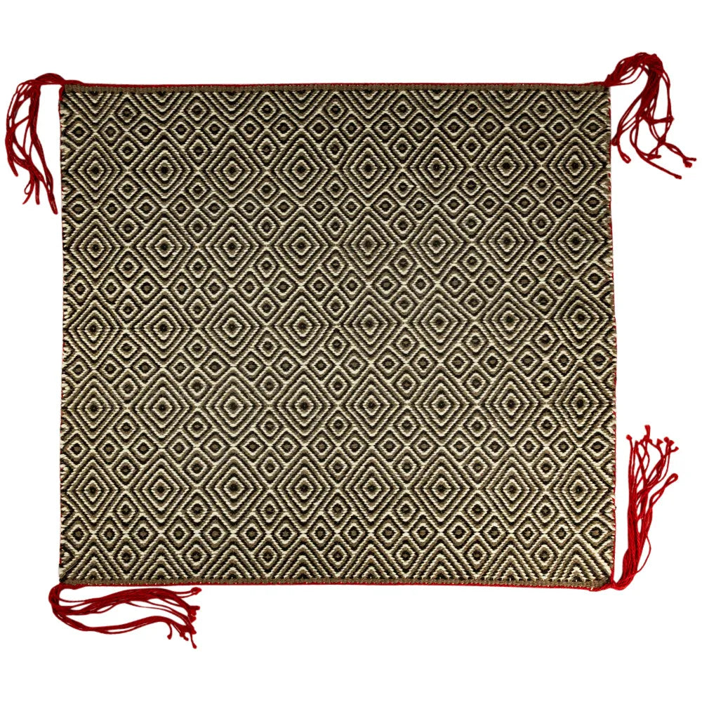 Handcrafted Navajo saddle blanket with geometric pattern and red tassels on a white background