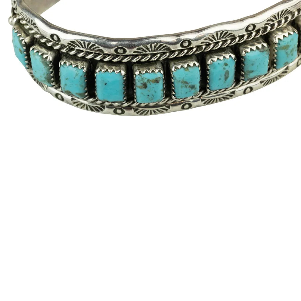 Silver bracelet with detail of turquoise stones on a white background