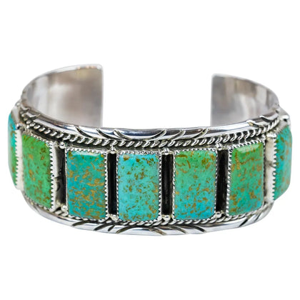 Silver bracelet with turquoise stones on a white background