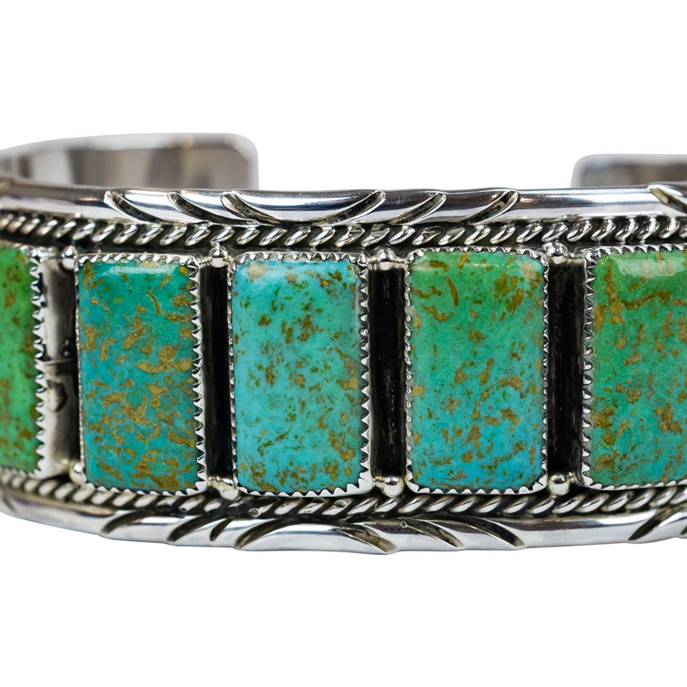Silver bracelet with turquoise stones on a white background