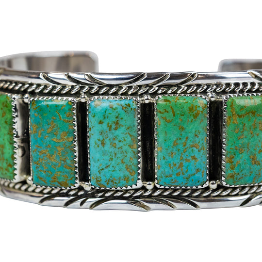 Silver bracelet with turquoise stones on a white background