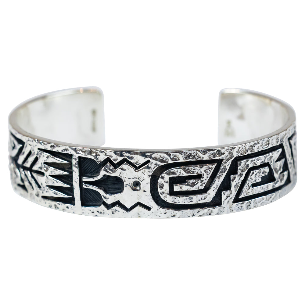 Silver bracelet with black tribal designs on a white background