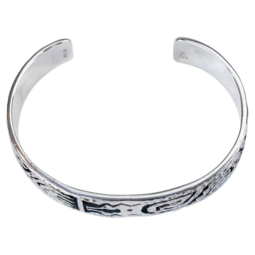 Silver bracelet with black tribal designs on a white background