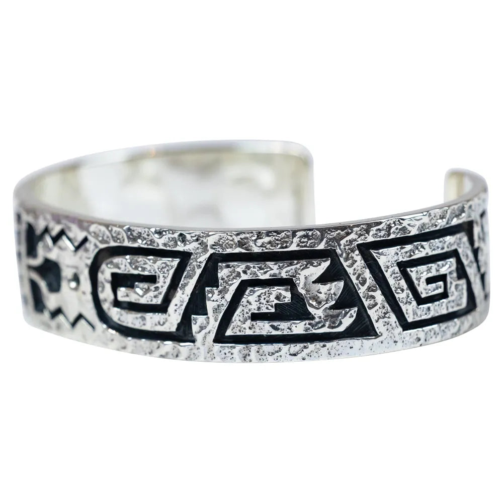 Silver bracelet with black tribal designs on a white background