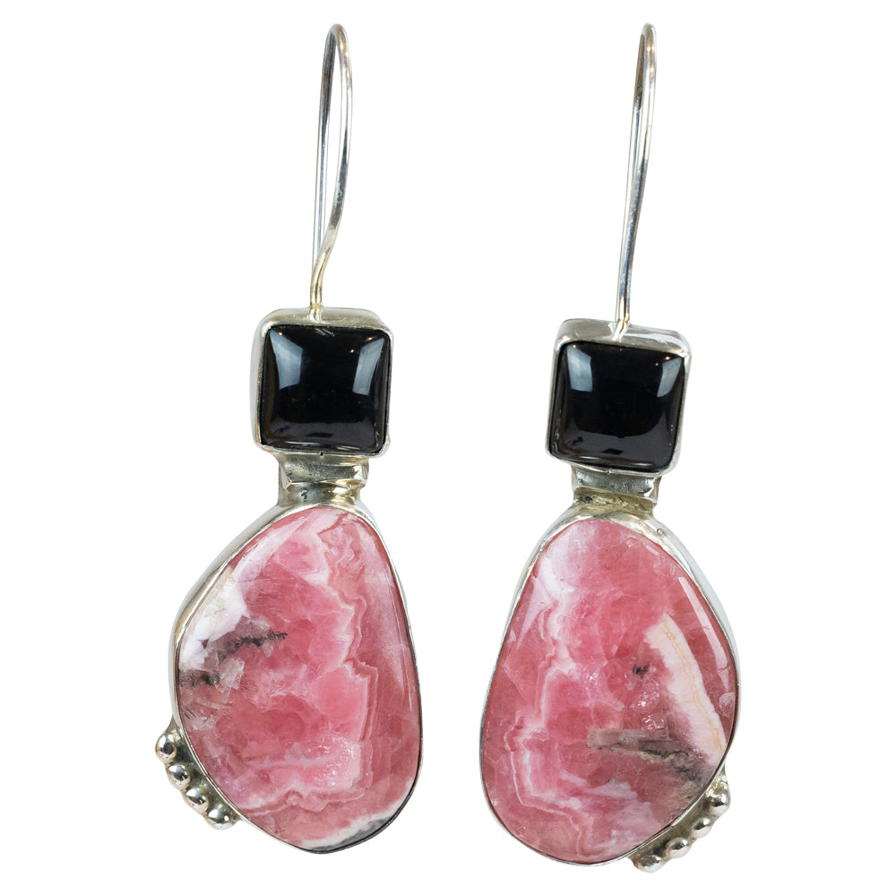 Pair of earrings with pink stones and black beads on a white background