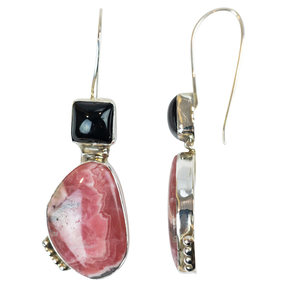 Pair of earrings with pink stone and black gem on a white background