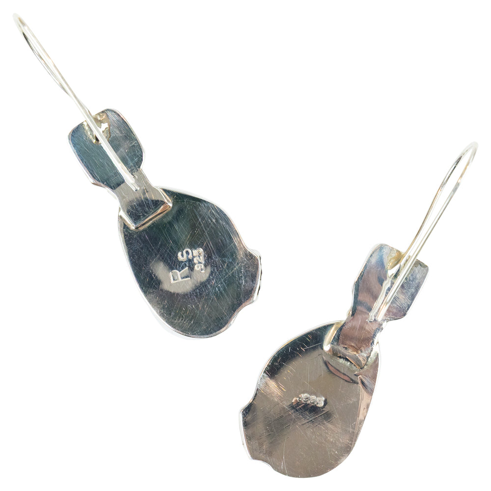 Pair of earrings with pink stone and black gem on a white background