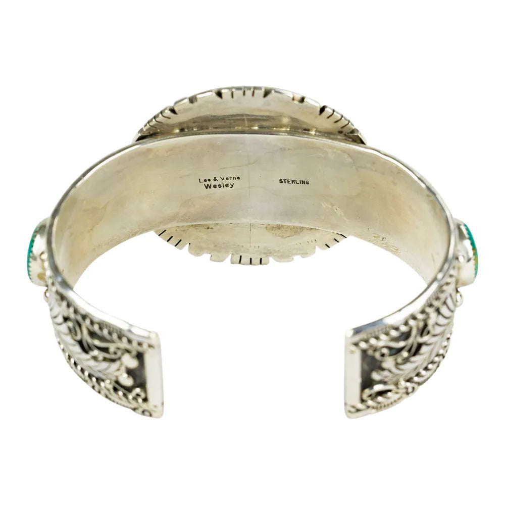 Silver bracelet with intricate designs and hallmark on a white background