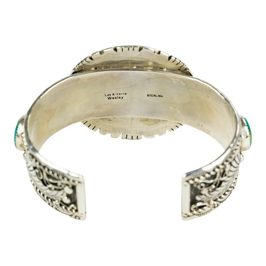 Silver bracelet with intricate designs and hallmark on a white background