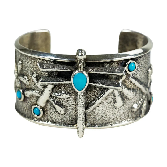 Silver Navajo cuff bracelet with turquoise stones on a white background