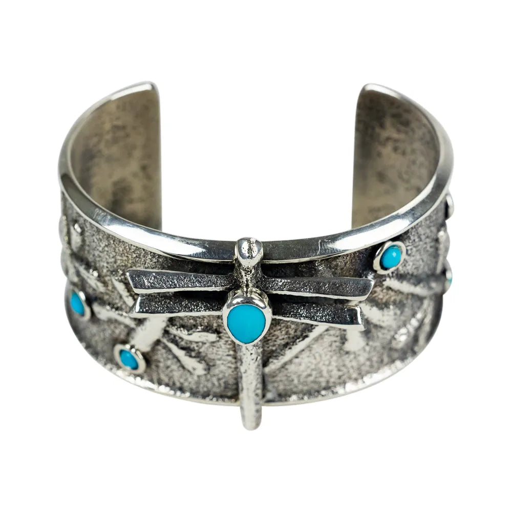 Silver cuff bracelet with turquoise stones on a white background