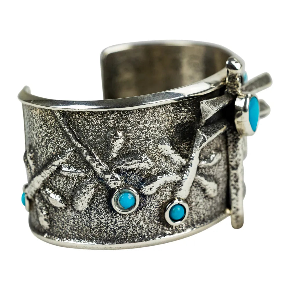Silver cuff bracelet with turquoise stones on a white background