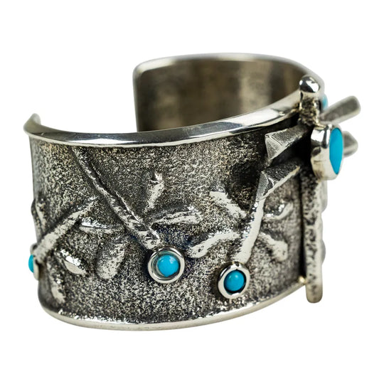 Silver cuff bracelet with turquoise stones on a white background