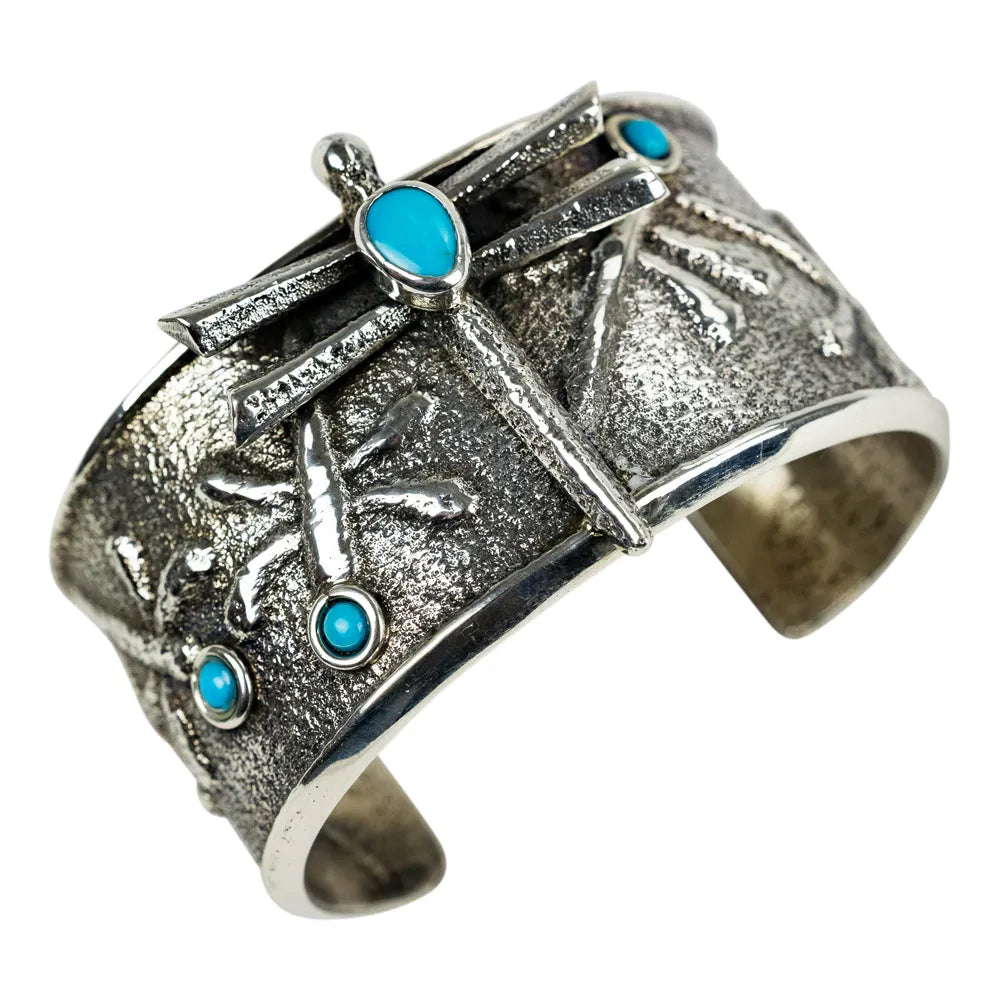 Silver cuff bracelet with turquoise stones on a white background