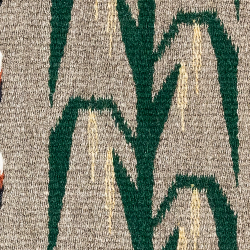 Close-up of a textured fabric with green and beige patterns on a gray background
