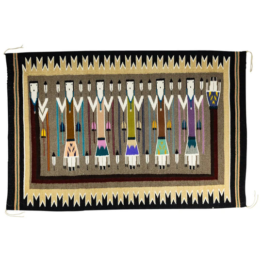 Handwoven Navajo textile with a pattern of Yei figures surrounded by a geometric pattern on a white background