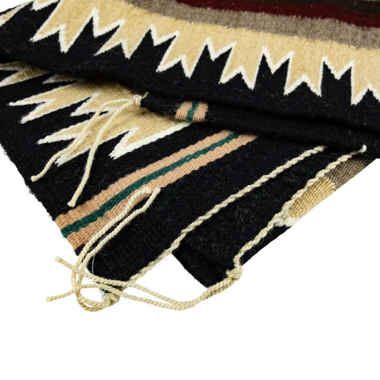 Close-up of a patterned Navajo rugt with geometric patterns on a white background
