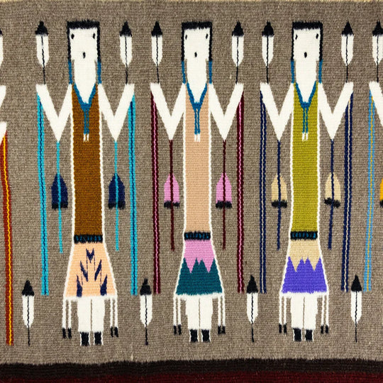 Handcrafter Navajo textile with stylized figures on a brown background