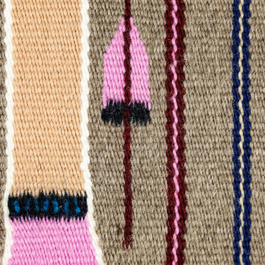 Close-up of a woven wool fabric with geometric patterns and colors.
