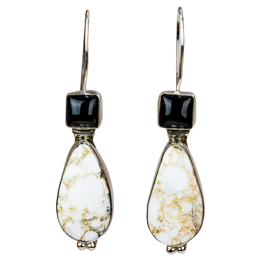 Pair of earrings with teardrop-shaped white stones and black square stones on a white background