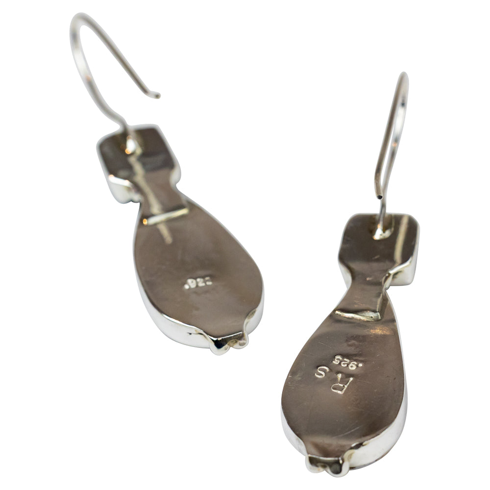 Pair of earrings with teardrop-shaped white stones and black square stones on a white background