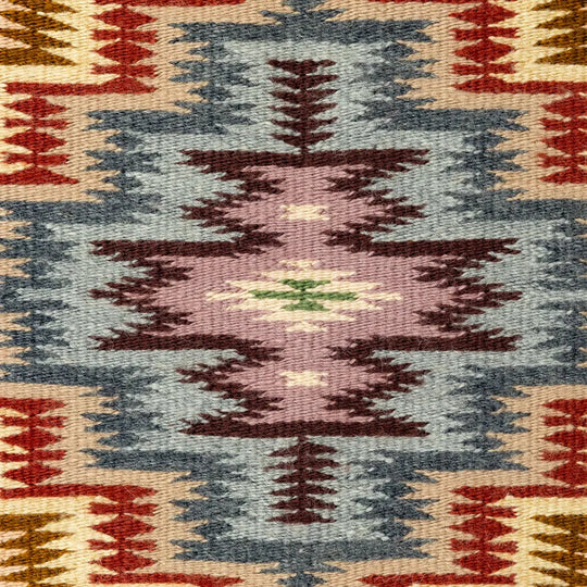 Close-up of a patterned fabric with geometric designs in red, blue, and brown.