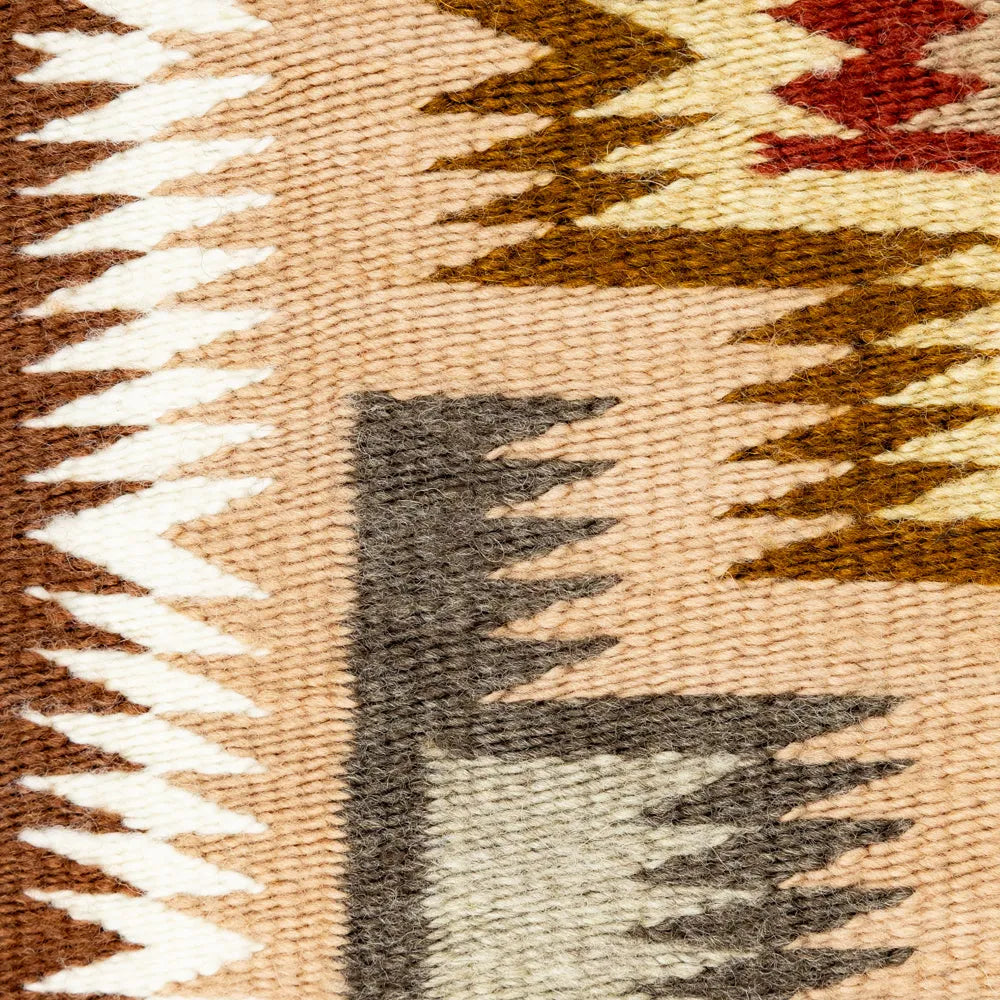 Close-up of a woven textile with geometric pattern featuring brown, beige, and white colors.