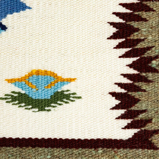 Close-up of a woven wool fabric with a bird design and geometric pattern