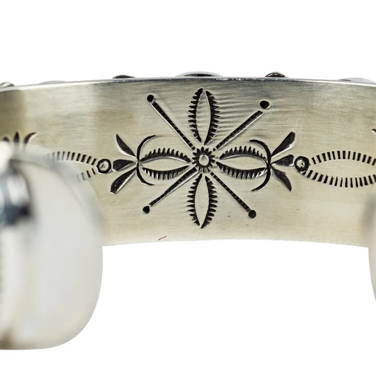 Close-up of a Sterling silver bracelt with intricate black floral design on a white background