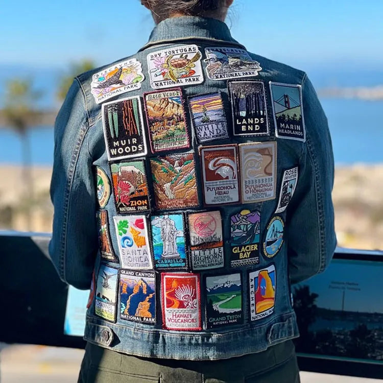 Person wearing jacket with several national park patches attached