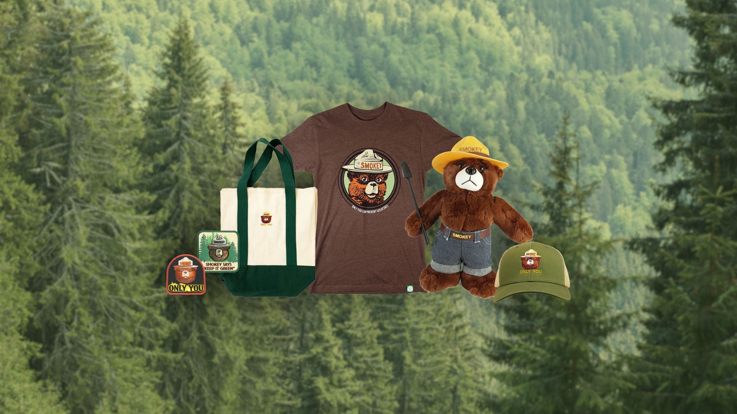 Collection of Smokey Bear-themed merchandise including a t-shirt, bag, and plush toy against a forest background.