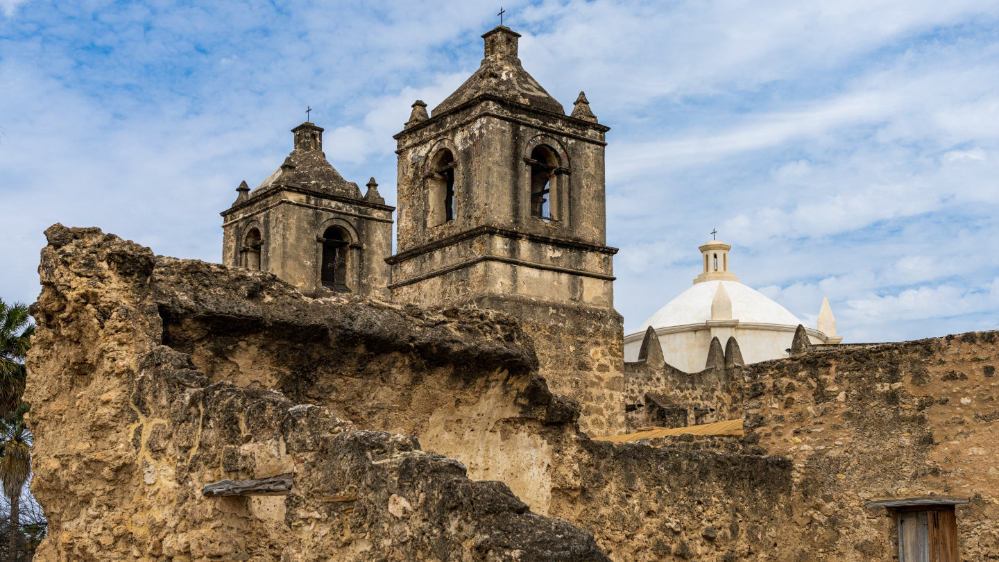 Historic stone building with bell towers against a blue sky