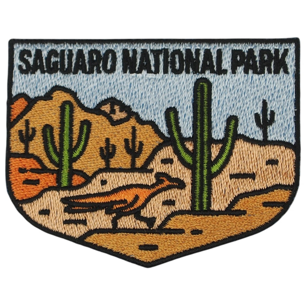 An embroidered patch of Saguaro National Park featuring green saguaro cacti, a desert landscape, and a bird under a light blue sky, with black text at the top and a black stitched border.