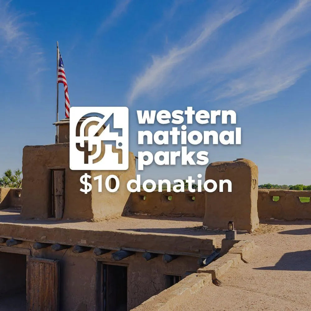 Traditional adobe building with American flag against a blue sky, featuring Western National Parks logo and text.