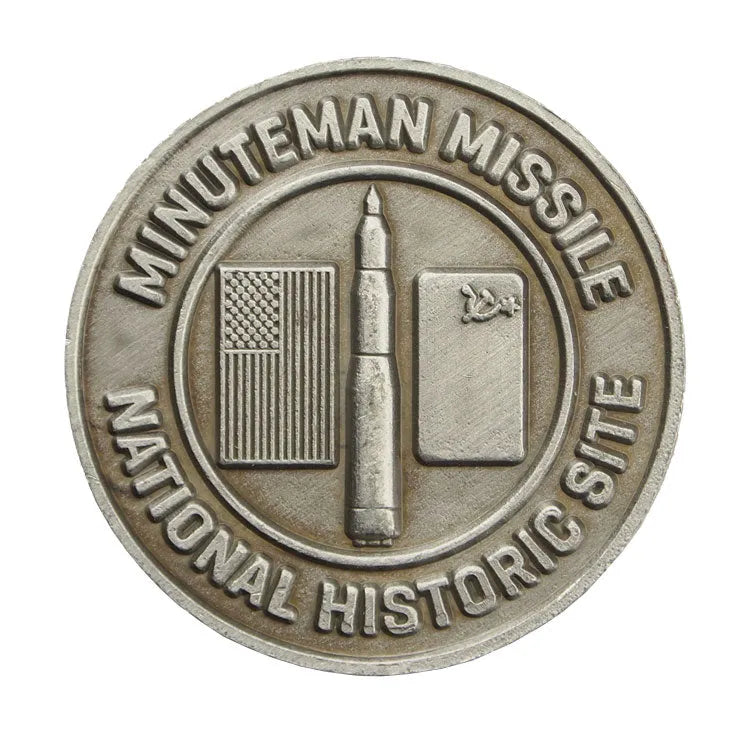 A collectible metal token with an image of the Minuteman Missile and the text 'MINUTEMAN MISSILE NATIONAL HISTORIC SITE'.